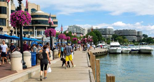 a group of people walking on a dock near the water at The Georgetown House Inn in Washington