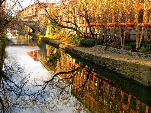 a river with trees and buildings and a bridge at The Georgetown House Inn in Washington