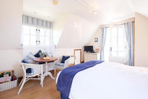 a bedroom with a bed and a table and chairs at The Bay Tree Studio in Thorpeness