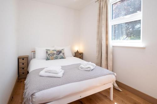 1 dormitorio con 1 cama con toallas en Three Tuns Apartments - Hazel en Pettistree