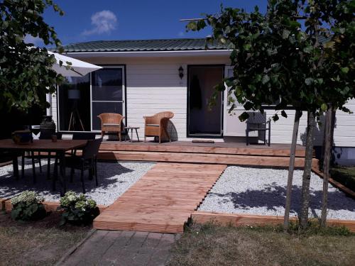 a patio with a table and chairs and a house at De Krukel in Sint Annaland
