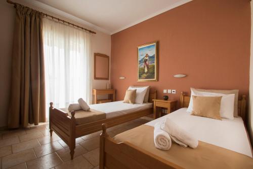 a hotel room with two beds and a window at Atira Apart Hotel in Olympiaki Akti