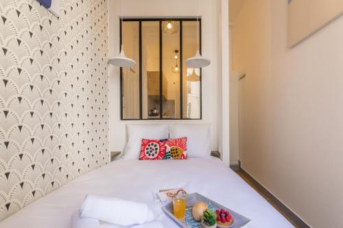 a small bedroom with a bed with a tray of food on it at Apartments WS Haussmann - La Fayette in Paris