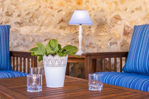 a table with a potted plant and glasses on it at La Font - Vallem Properties in Pollença