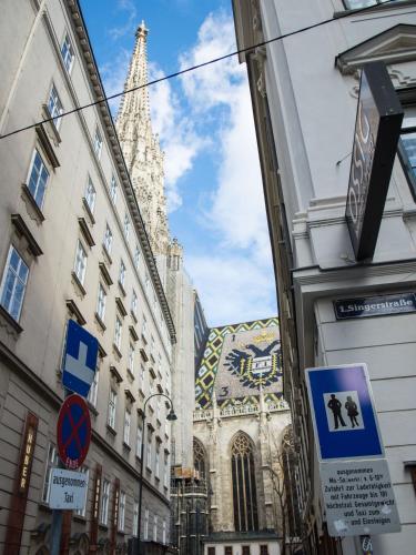 a church with a tower in the middle of a street at Nikolai Homes in Vienna