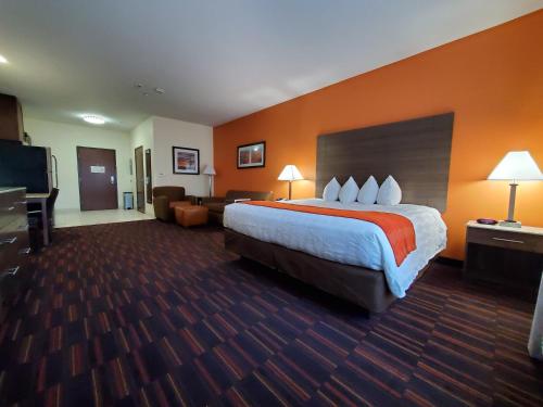 a hotel room with a large bed and a living room at Home Away Kitchen Suites Enid in Enid