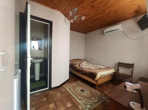1 dormitorio con 1 cama y lavamanos en una habitación en Guest House on Chernomorskaya Ulitsa, en Anapa
