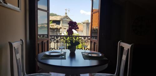 a dining room table with a view of a window at Atico Mirador Rualeira in Combarro