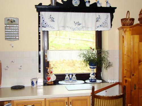a kitchen with a window with blue and white dishes at Agroturystyka Łysa Góra in Jelenia Góra