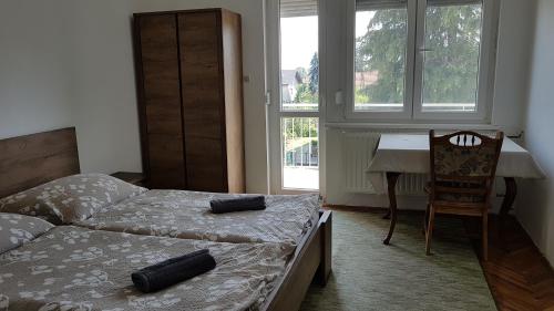 1 dormitorio con 2 camas, escritorio y silla en Naperkély Apartman, en Badacsonytomaj