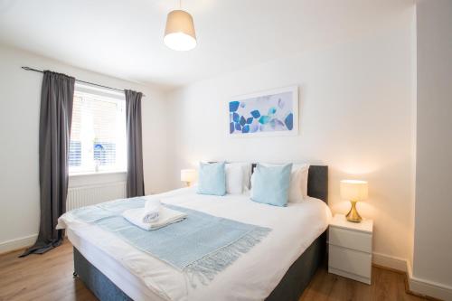 a bedroom with a large bed with blue pillows at Velvet 1-bedroom apartment, Clockhouse, Hoddesdon in Hoddesdon