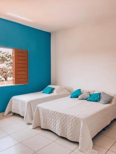 two beds in a room with blue walls at Mansão Beberibe in Beberibe