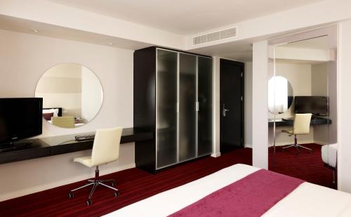 a bedroom with a bed and a desk and a mirror at Park Plaza Leeds in Leeds