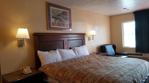a hotel room with a bed and a telephone at Garden Inn and Extended Stay in Shepherdsville
