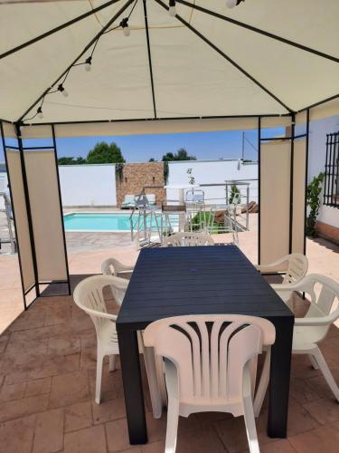 a black table and chairs under a tent with a pool at Las Eras 2 in Herencia