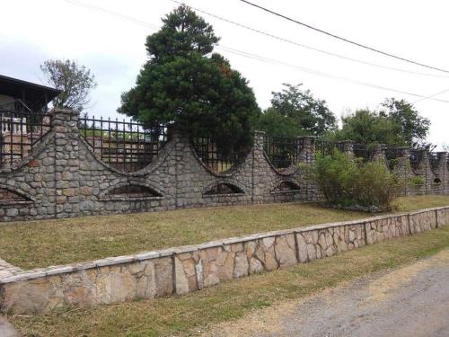 a stone wall with a tree on top of it at VILA PEKEČ in Mala Moštanica
