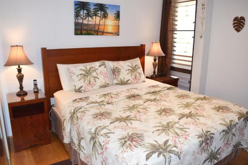 a bedroom with a bed with palm trees on it at Maui Vista 2406 in Kihei