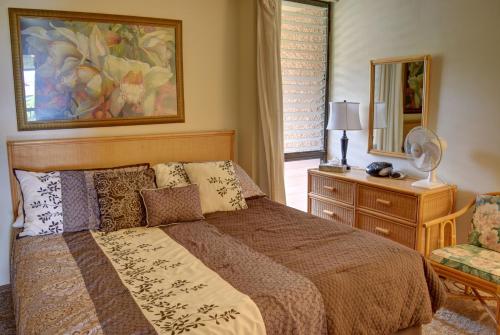 um quarto com uma cama, uma cómoda e um espelho em Maui Vista 3205 em Kihei