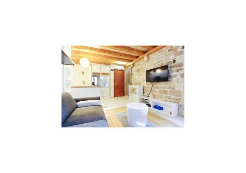 a living room with a couch and a stone wall at Apartment Capo Family & Capo Studio -Old Town-Parking in Trogir