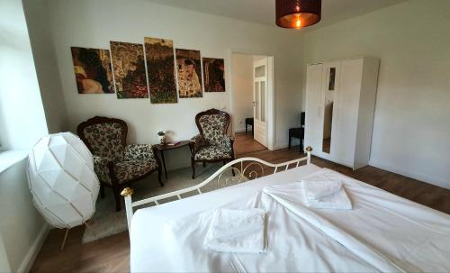 - une chambre avec un lit blanc, une table et des chaises dans l'établissement Pineapple Apartments Dresdner Heide mit Garten, à Dresde