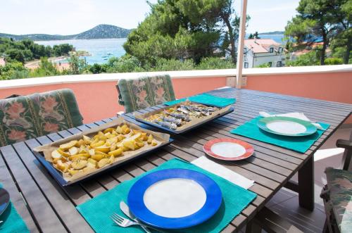 a wooden table with a tray of food on it at Milica Garden in Prvić Šepurine