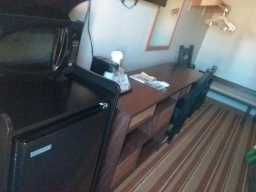 a kitchen with a wooden table and a refrigerator at Super 8 by Wyndham Taos in Taos