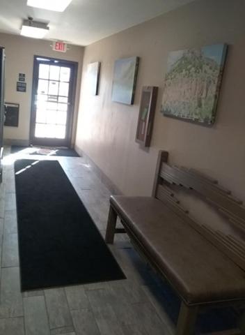 a hallway with a bench in a room with a door at Super 8 by Wyndham Taos in Taos
