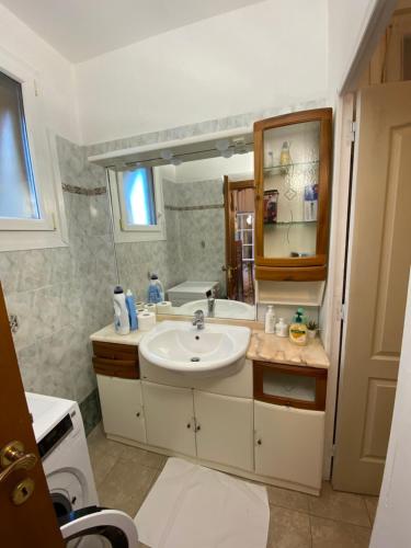 y baño con lavabo y espejo. en Giadera penthouse 5terreparco, en Riomaggiore