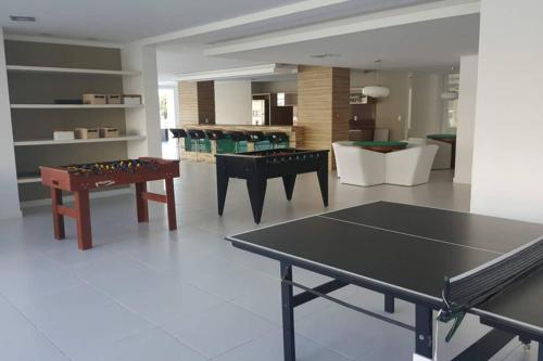 ein Wohnzimmer mit einer Tischtennisplatte und Stühlen in der Unterkunft Marine Home Resort- piscina aquecida-hidromassagem in Florianópolis