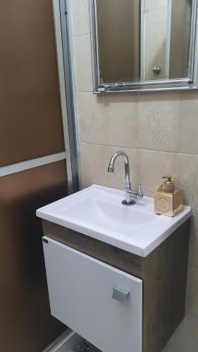 y baño con lavabo blanco y espejo. en Apartamento sala living, en Santos