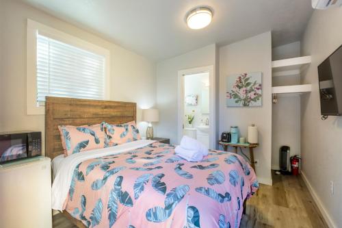 a bedroom with a bed with a pink and blue comforter at @ Marbella Lane Mini Guest House in Downtown San Jose in San Jose