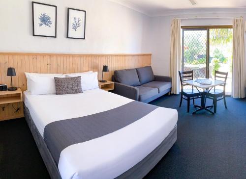 a hotel room with a large bed and a couch at Costa Rica Motel in South West Rocks