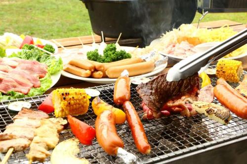 a grill with many different types of food on it at Irie House Fuchaku in Onna