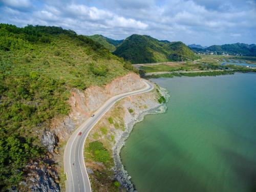 an aerial view of a road next to a body of water at Flamingo Resort Cat Ba in Cat Ba