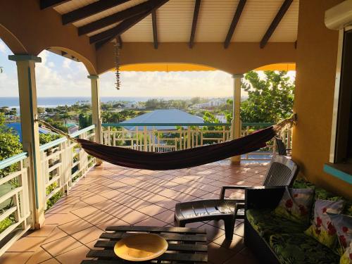 a hammock on a porch with a view of the ocean at Appartement spacieux à Saint-François 150 m² avec piscine partagée ! in Saint-François