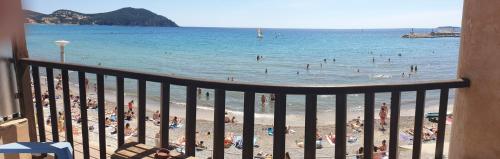 a beach filled with lots of beach chairs and umbrellas at Hotel Chanteplage in Saint-Cyr-sur-Mer