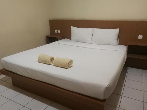 a bedroom with a large bed with two towels on it at Hotel Mayang Sari 2 in Jambi