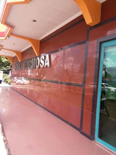 a red wall with the sign for the disney train station at Hotel Formosa Jambi in Paalmerah