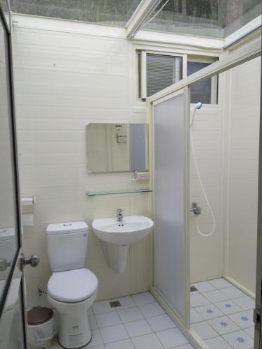 a bathroom with a toilet and a sink at Yun Ting Orchid Garden in Sanyi