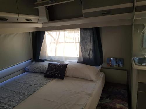 ソゾポルにあるCaravan Sozopolの窓付きの小さな部屋の小さなベッド1台分です。
