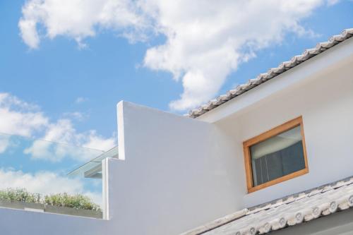 a white house with a window and the sky at Shang Shan ruo shui 大理上山若水客栈 in Dali