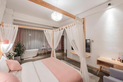 a bedroom with a canopy bed and a bath tub at Shang Shan ruo shui 大理上山若水客栈 in Dali