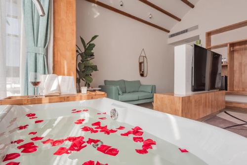 a living room with a white tub with red flowers on it at Shang Shan ruo shui 大理上山若水客栈 in Dali