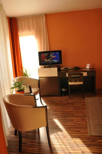 a living room with a television and a table and chairs at Penzion Beryl in Košice