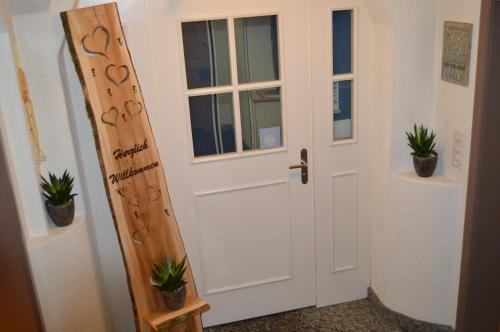a white door with potted plants in a room at Hotel Garni Rösslipost in Unteriberg