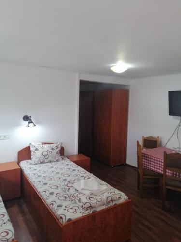 a small room with a bed and a dining room at vila elly in Piatra Neamţ