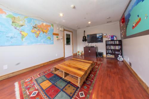 una sala de estar con una mesa y un mapa en la pared en Squamish Adventure Inn, en Squamish