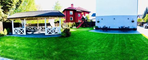 a yard with a gazebo and a red house at Przystań Stegna in Stegna