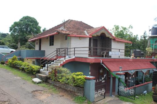 a house with a red roof with a staircase on it at Chuppi Homestay in Madikeri