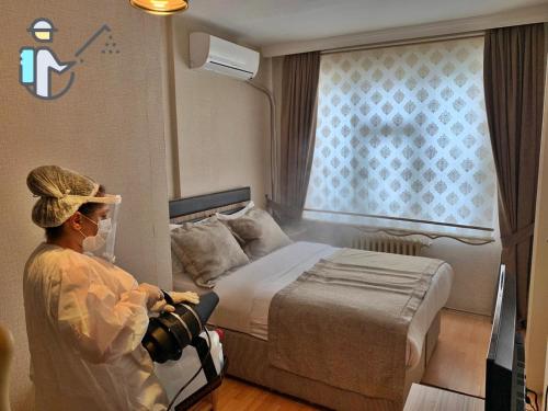 a woman with a camera in a hospital room at Cmr Aydogan Hotel in Rize